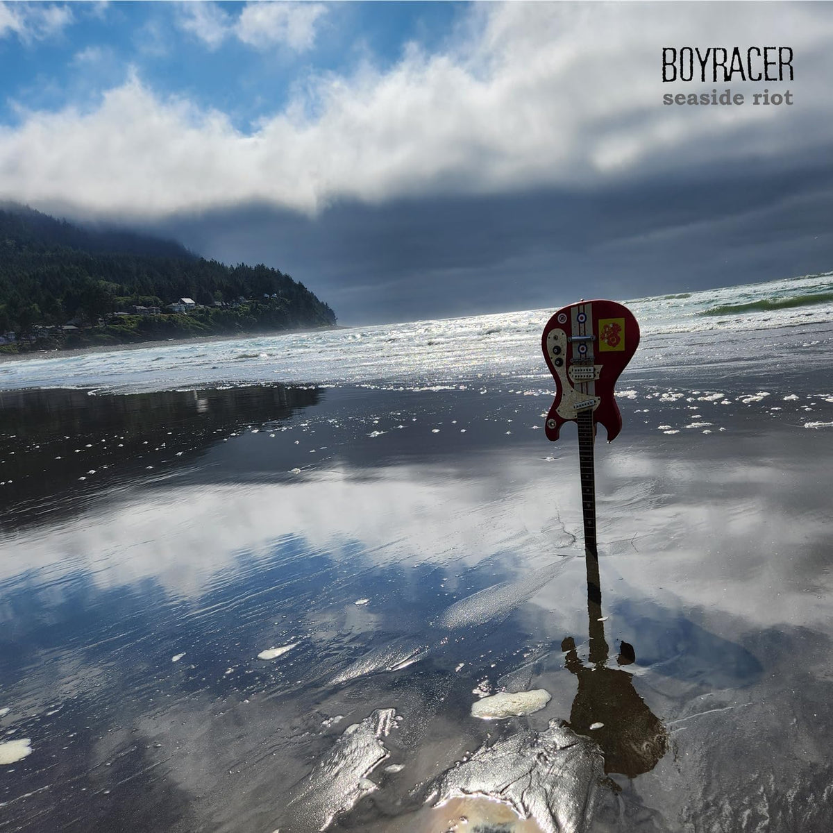 Boyracer album cover: electric guitar on a beach under cloudy skies.