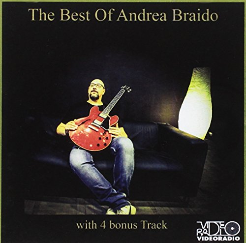 Andrea Braido sits with a red guitar on a dark couch.