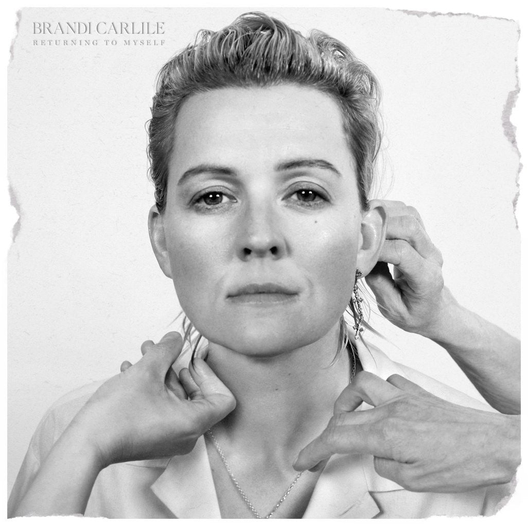 Black and white portrait of Brandi Carlile with hands touching her face.
