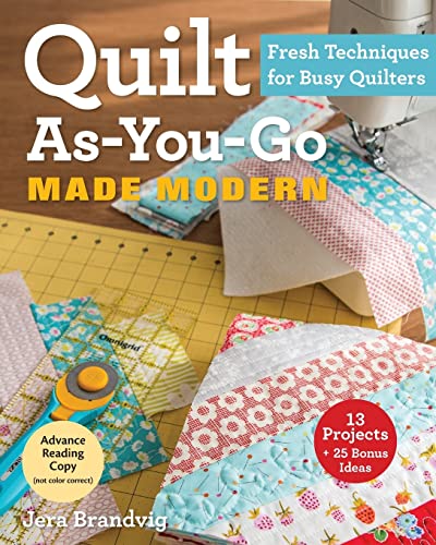 Quilting book cover with colorful fabric, rotary cutter, and sewing machine.