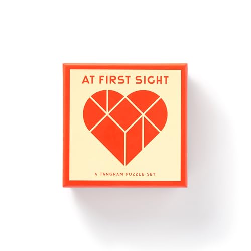 Red and cream box for "At First Sight" tangram puzzle with heart design.