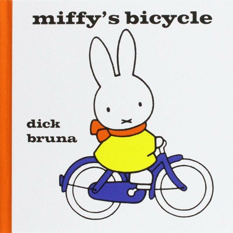 Miffy the rabbit wearing a yellow shirt and orange scarf riding a blue bicycle.