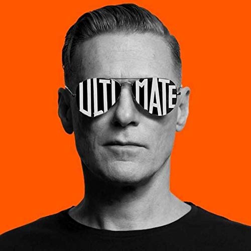 Black and white portrait of Bryan Adams wearing sunglasses with Ultimate written on lenses.