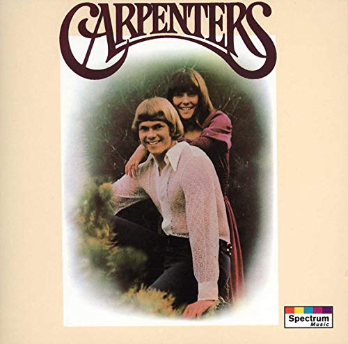 Two musicians outdoors, man kneeling with woman behind him, on album cover.