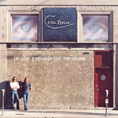 CD cover: building facade with large eye images and two men.