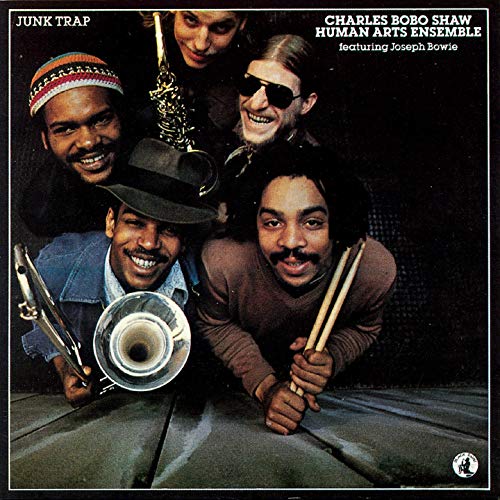 Album cover for "Junk Trap" featuring four musicians with instruments.