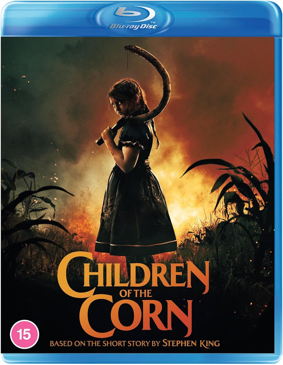 A girl in a dark dress holds a sickle standing before a burning cornfield.