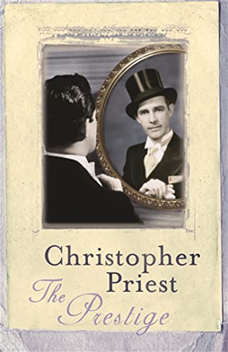 A man in a top hat and tuxedo looks into an oval mirror.