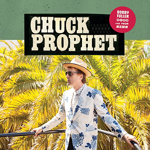 Chuck Prophet wearing a hat and floral blazer against a background of palm leaves.