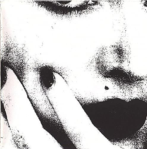 Grainy black and white close-up of a person’s face, partially obscured.