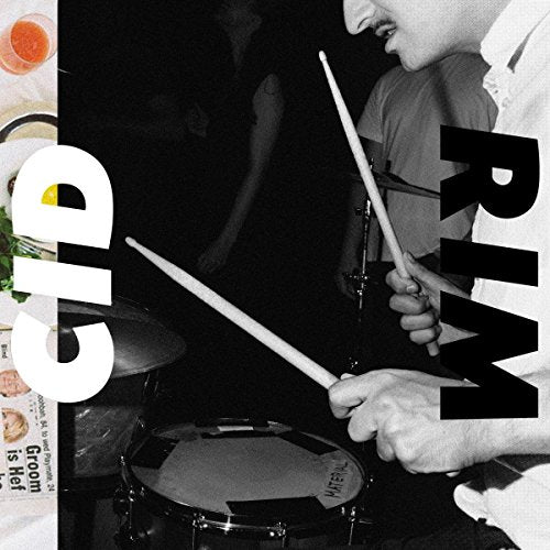 Black and white photo of a drummer playing with sticks, with large text overlay.