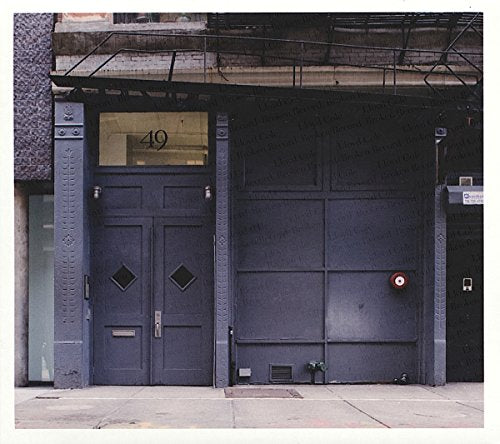 The image depicts a building facade with a dark gray door and large garage door. #### Alt text: Dark gray door and large garage door on a building facade.