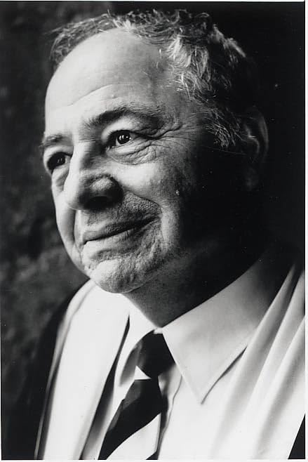 Black and white portrait of an older man in a suit and tie.