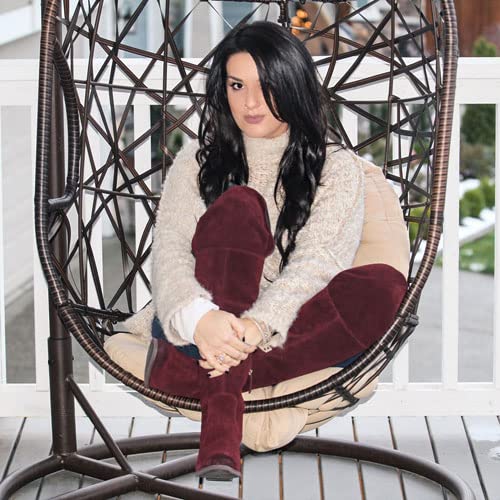 Woman with long dark hair sitting in a hanging chair.