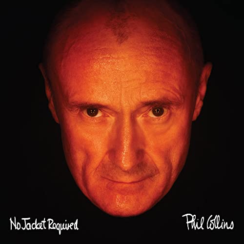 Close-up portrait of Phil Collins illuminated in orange against a black background.