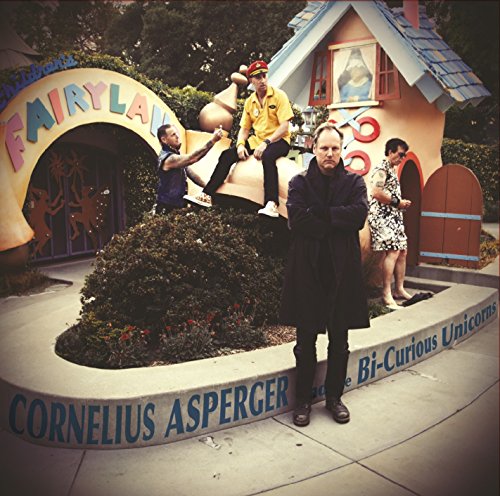 Four people pose near a colorful fairytale-themed structure and signage.