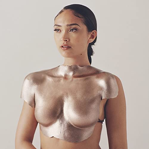 Portrait of Joy Crookes with metallic gold covering her upper body.