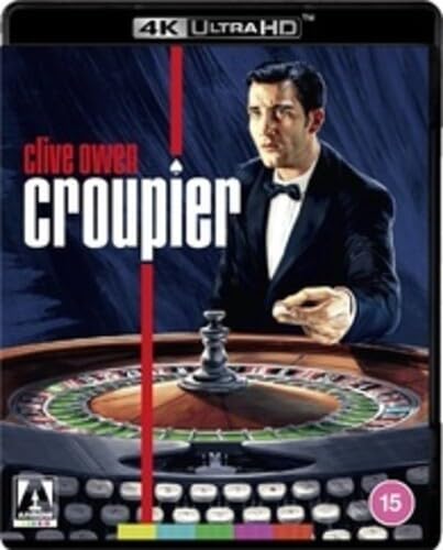 Clive Owen in a tuxedo standing behind a roulette wheel on a movie cover.