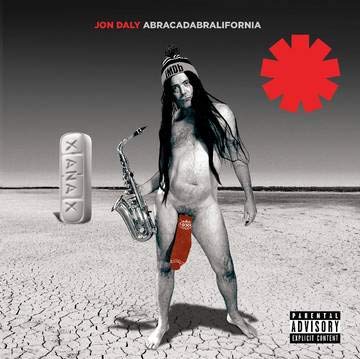 Naked man with long hair holding saxophone in desert with pill and red symbol.