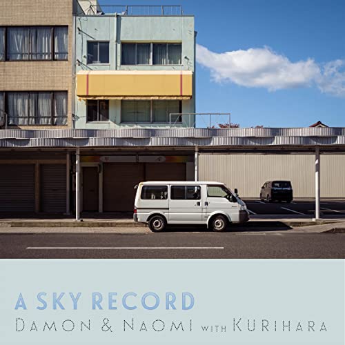 Vinyl record cover: building facade, white van, blue and white color scheme.