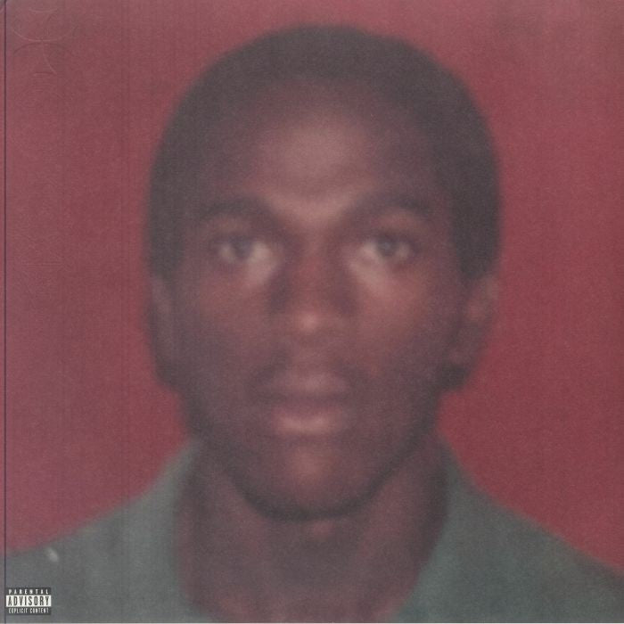 Close-up portrait of Daniel Caesar against a red background, vinyl record.