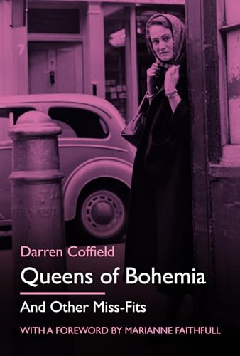 A woman in a headscarf and coat stands on a street near a car.