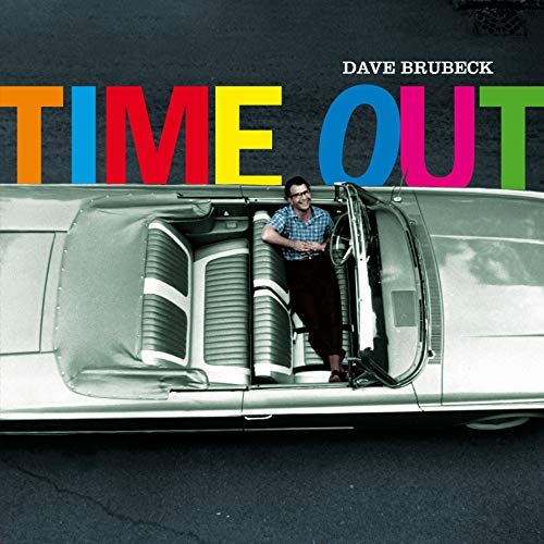 Dave Brubeck sits in a convertible under the colorful text Time Out.