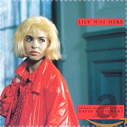 Blonde woman wearing a red jacket on the Lily Was Here album cover.