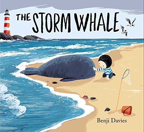 A child in a striped shirt touches a small whale beached on the sand.