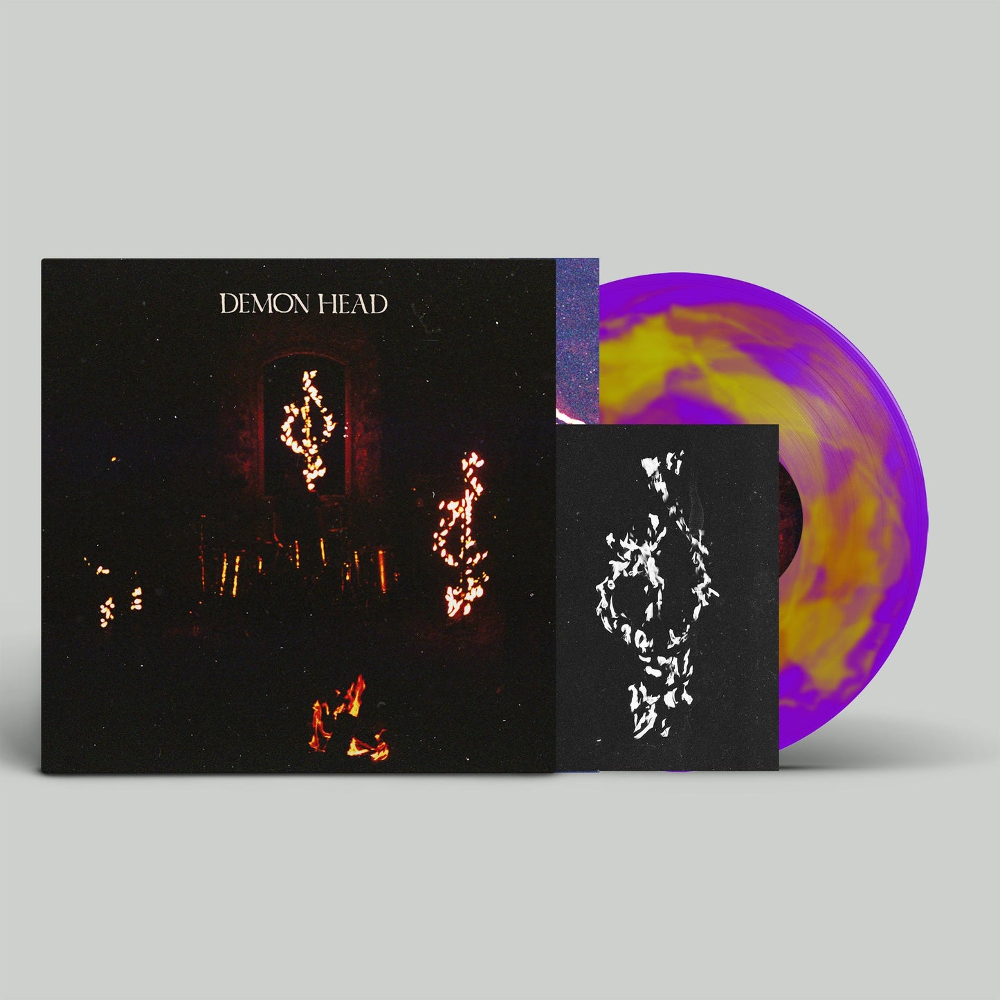 Vinyl record with colorful swirls, album cover with dark, fiery imagery.
