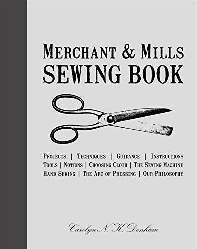 "White book cover with 'Merchant & Mills Sewing Book' title, scissors illustration, and author signature."