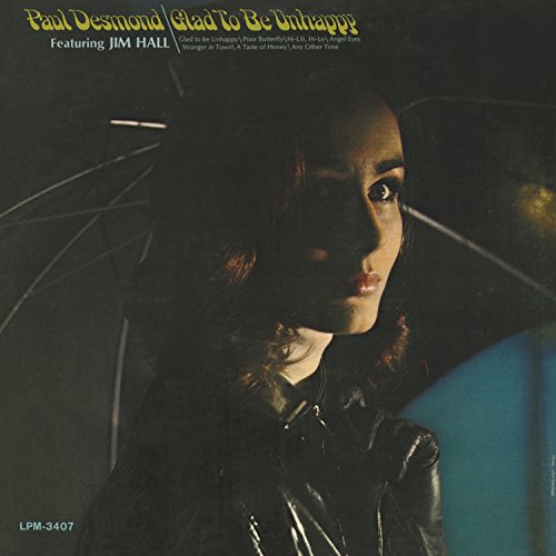 CD cover: woman’s face shadowed by an open black umbrella, gold text.