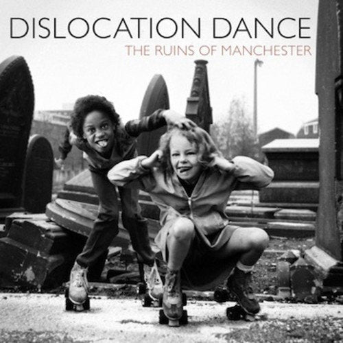 Black and white album cover with two children roller skating in a ruined area.