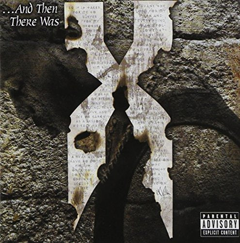 Large X-shaped metal plate with burnt edges and text against a dark stone wall.