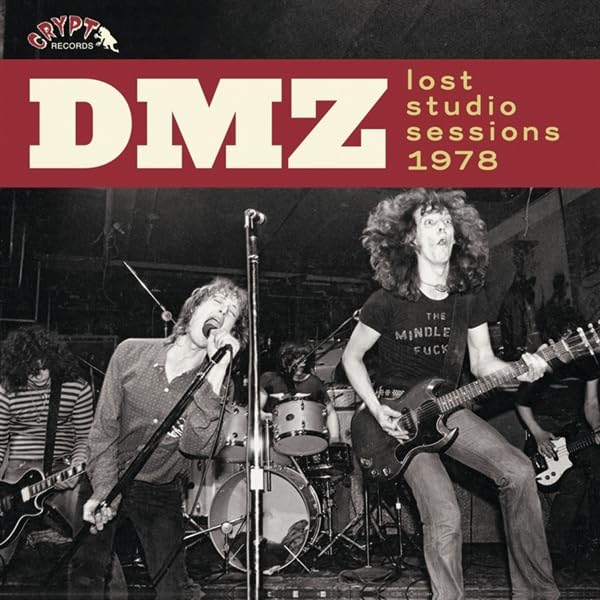 Black and white photo of the band DMZ performing live on stage.
