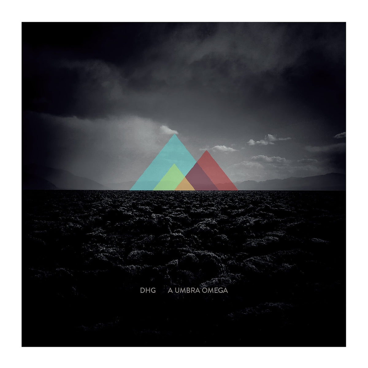 Overlapping colorful triangles sit above a dark, rocky landscape under a cloudy sky.