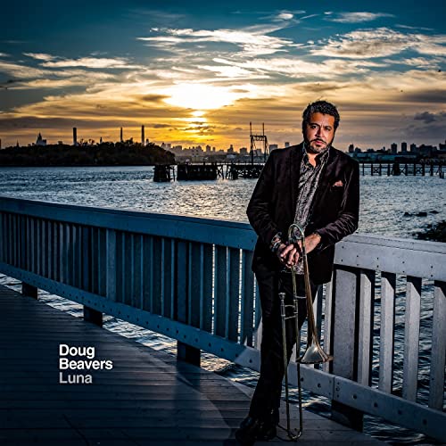 Doug Beavers holding a trombone, sunset cityscape in the background.