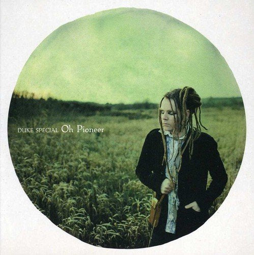 CD album cover with a man in a field, wearing a black jacket and dreadlocks.
