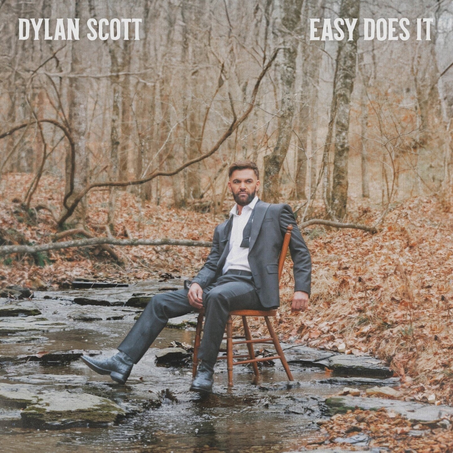 Dylan Scott album cover: man in suit seated by a stream.
