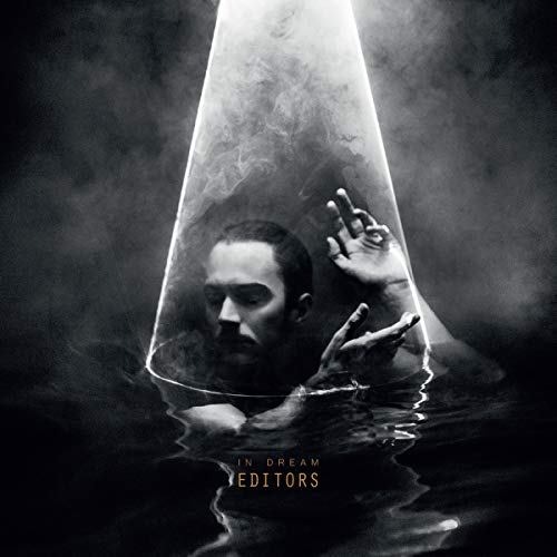 A man submerged in water under a spotlight, with album text below.