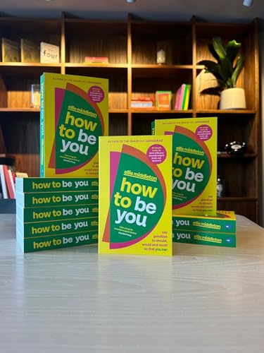 Yellow and green book cover, "How to be You," stacked on a table.