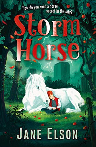 A boy with red hair sits reading against a white horse in a park.