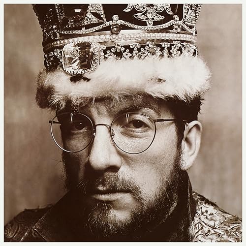 Sepia-toned portrait of Elvis Costello wearing a crown and glasses.
