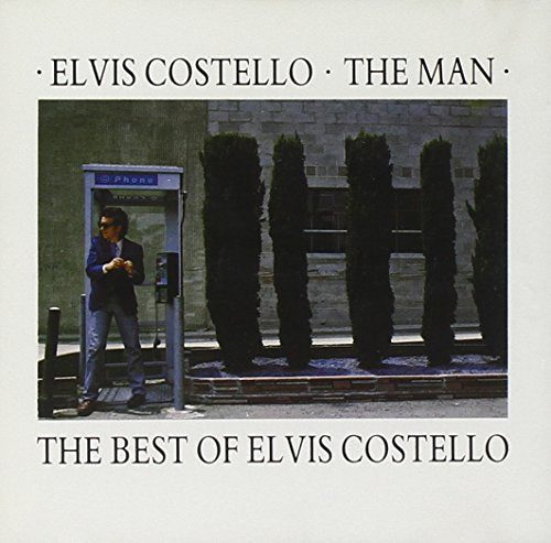 CD cover: Elvis Costello standing by a phone booth, green hedges.