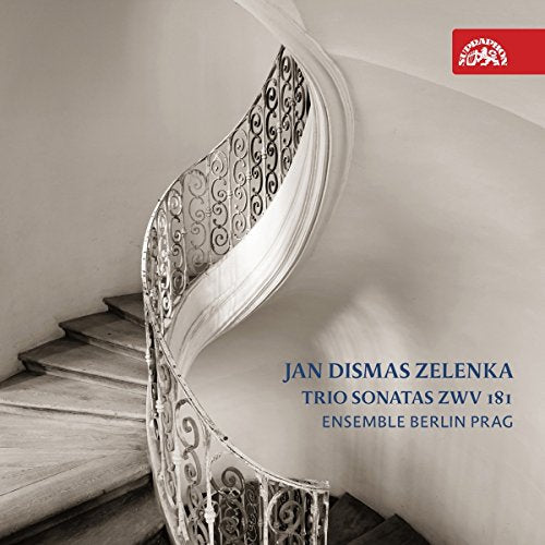 A curved wooden staircase with an ornate metal railing in a sepia-toned room.