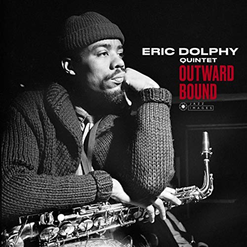 Black and white portrait of Eric Dolphy holding a saxophone, wearing a knit cap.
