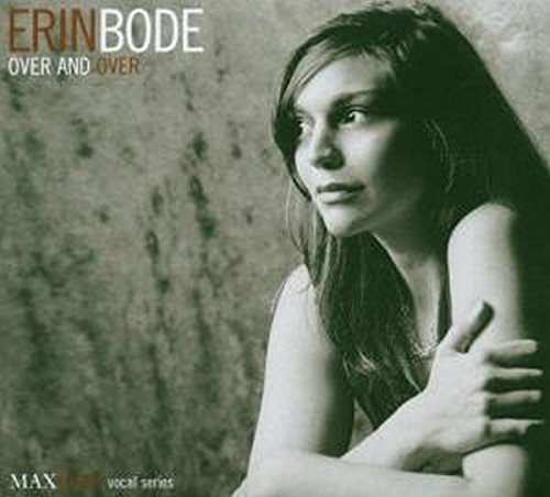 A black and white album cover with a woman leaning against a textured wall.