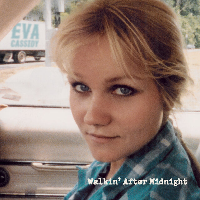 Close-up portrait of Eva Cassidy in a car with a truck in the background.