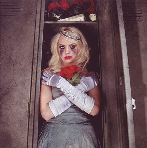 Woman with dark eye makeup and roses inside a metal locker.