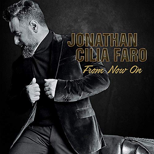 "Album cover featuring a man in a dark suit, with gold text."